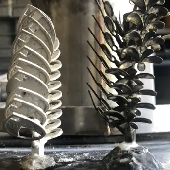 Two cast metal trees, one silver and one dark