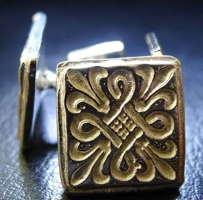 Square cufflinks with an ornate raised motif