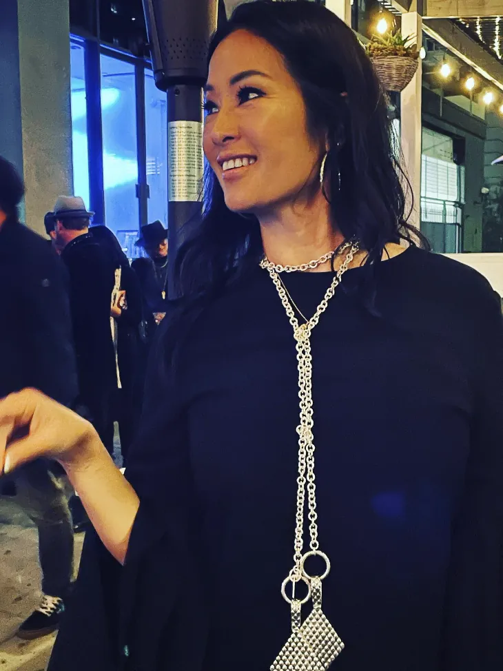 Woman at an evening event wearing a long silver lariat